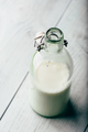 Almond milk in glass bottle on wooden surface - PhotoDune Item for Sale