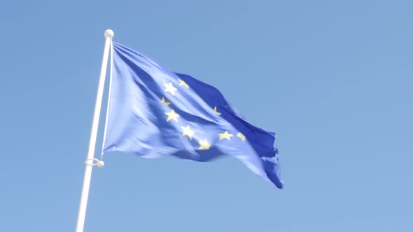 Silk fabric of European Union flag in front of blue sky waving on wind 4K 2160p UltraHD footage - EU
