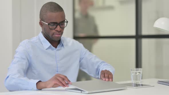 African Man Leaving Office After Work Closing Laptop