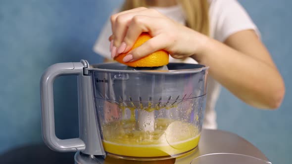 Woman making orange juice. Close up of woman making juice with fresh orange