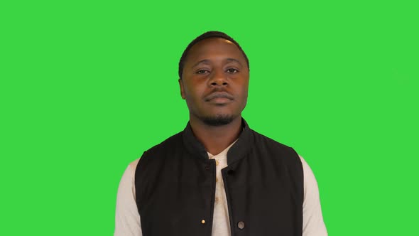 Happy African American Man Putting His Sunglasses on and Smiling on a Green Screen Chroma Key