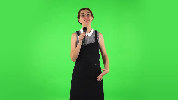 Funny Girl in Round Glasses Is Singing Into a Microphone and Moving To the Beat of Music. Green