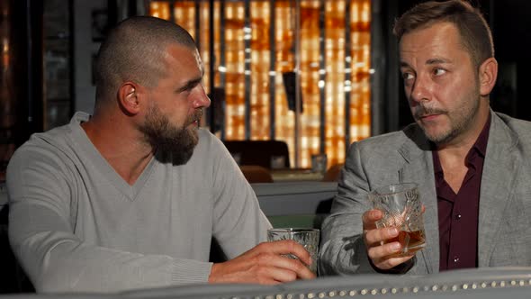 Two Male Friends Enjoying Whiskey at the Bar Together