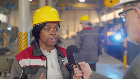 Female Engineer Giving Interview about Factory to TV Journalist