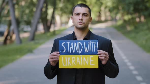 Portrait Sad Serious Man Activist Patriot Guy Stand Outdoors Hold Cardboard with Written Inscription