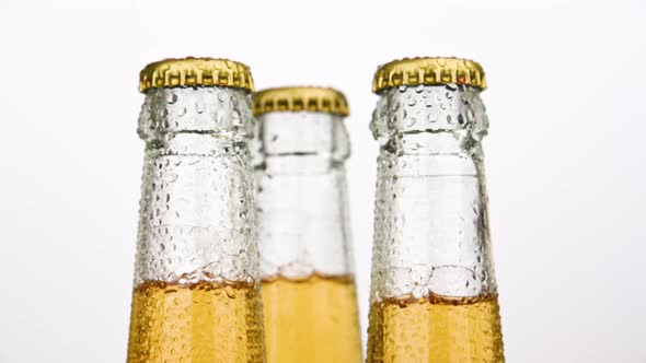 Three beer bottles rotating over white