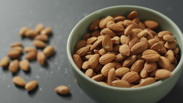 Video of fresh fruit almonds in a bowl on grey background