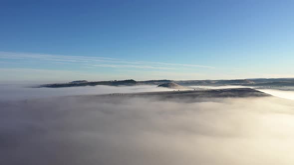 Flying Over Hills in Mystic Foggy Winter Morning. Aerial View