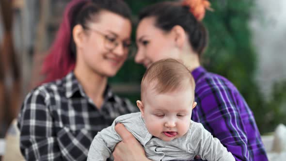 Closeup Little Cute Baby Holding By Hand of Same Sex Couple Having Good Time Together at Home