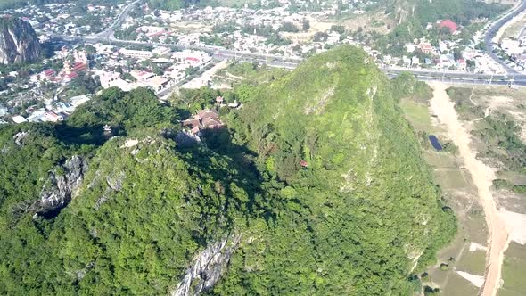 Bird Eye Flight Over Temple Roofs on Hill Surrounded By Road