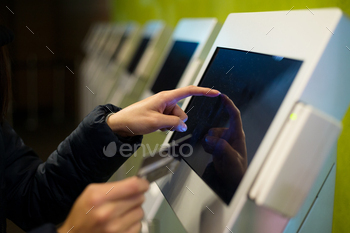 Woman touch on screen of automatic ticketing system