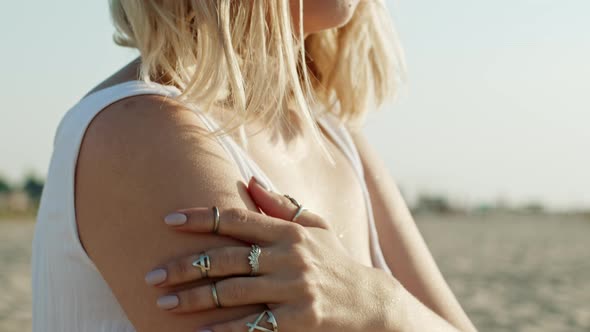 Young Unrecognizable Woman Caressing Her Shoulder, Strokes Body on Sandy Beach. Beautiful Girl