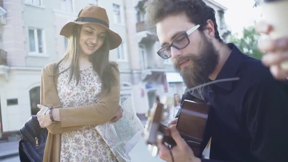 Young Woman Listening To Street Musician