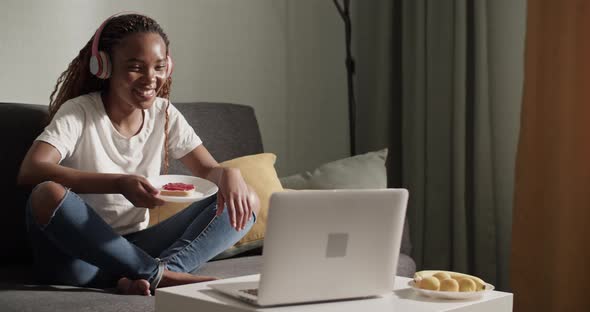 African American Female Eating Toast and Watching Movie