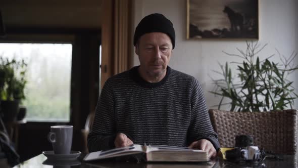 Man In Woolly Hat Closing Photograph Album