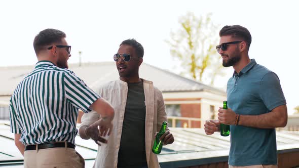 Happy Male Friends Drinking Beer at Rooftop Party