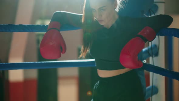 An Attractive Young Woman with Long Hair Resting on the Boxing Ring