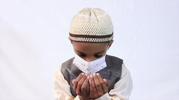 A Muslim child wearing a mask praying to Allah, God 4k footage