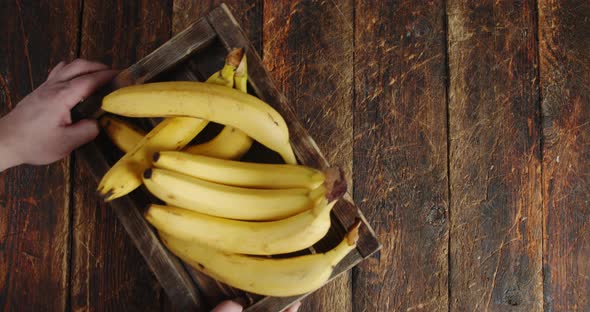 Male Hand Put Fresh Bananas on the Tray. 