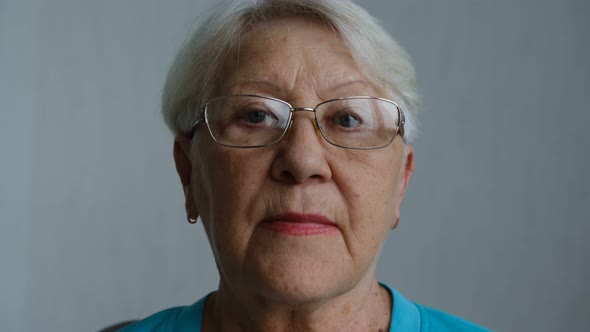 Close up portrait of senior woman with gray eye's looking at the camera in glasses.