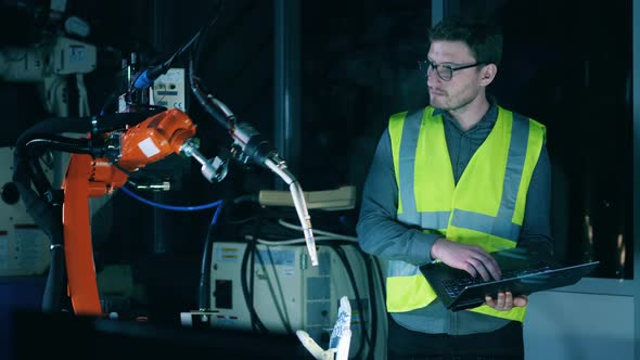 Science Worker in Safety Wear Is Working with a Robotic Device