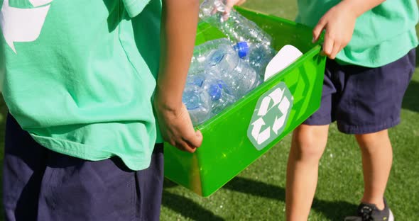 Mid section of schoolkids carrying plastic bottles waste  in the school playground 4k