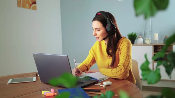 Girl Student in Headphones Learns Laptop Video Calling App