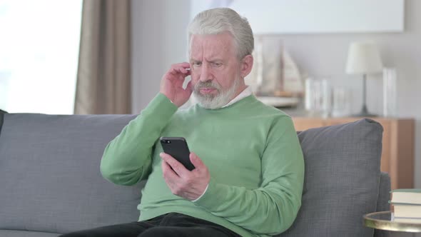 Sad Old Man Having Failure on Smartphone at Home