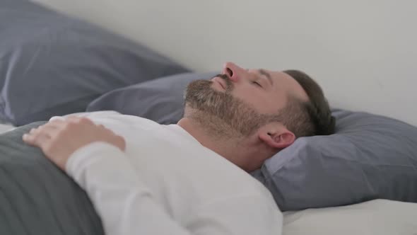 Man Waking Up From Nightmare in Bed