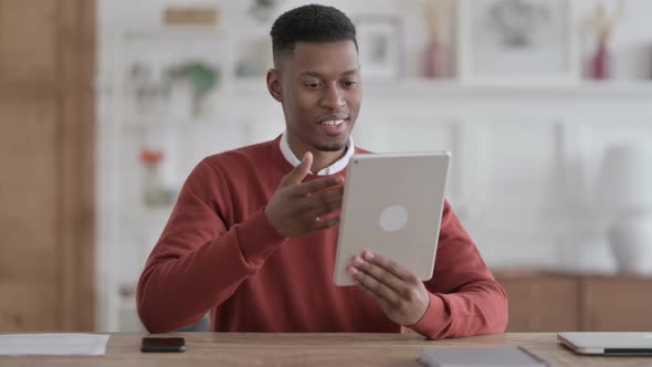 African Man making Video Call on Tablet in Office