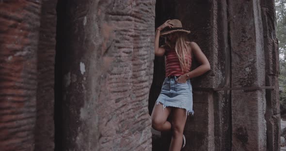 Blonde Female Leaning on a Structure While Posing for the Camera