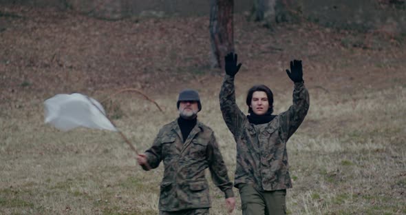 Military Men Waving White Flag And Gesturing During War