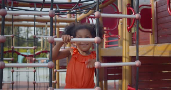 African Kid Having Fun with Climbing Net Outdoors