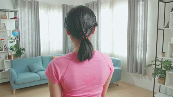 Back View Of Asian Woman Training On Walking Treadmill At Home