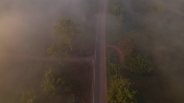 4K High mountain road in fog. Tropical forest with smoke and fog. Aerial view from drone