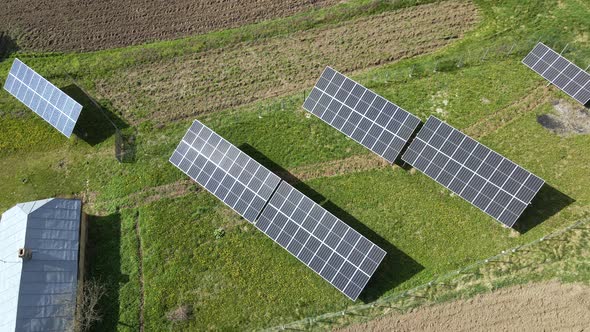 Aerial View of Blue Photovoltaic Solar Panels Mounted on Backyard Ground for Producing Clean