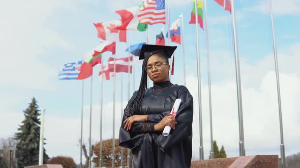 Young African American Woman Rejoices with a Diploma of Higher Education in Her Hand Standing