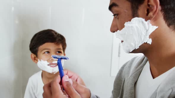 Father and son shaving together