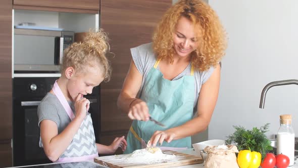 Happy Mother with Little Daughter in Home Kitchen