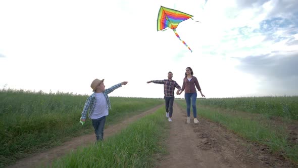 Family Idyll, Little Boy with Kite in His Hands Runs on Countryside in Slow Motion on Background of