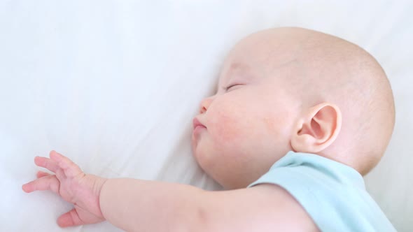 Closeup Portrait of Sleeping Infant Three Months Baby in White Bed Waking Up