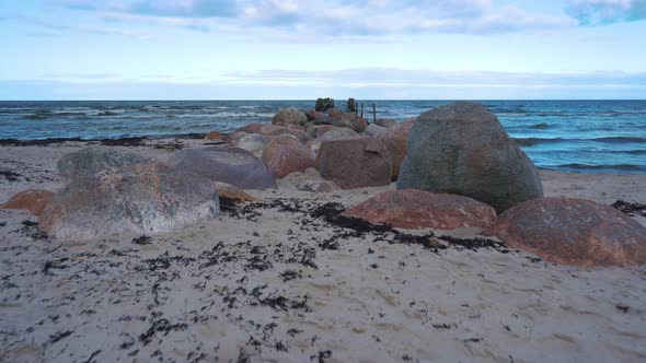 Remains of an Old Pier on Seaport. Rocks and Logs.