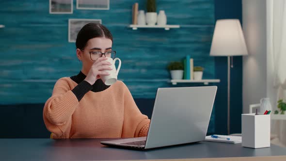 Young Adult Browsing Internet on Laptop to Do Remote School Work