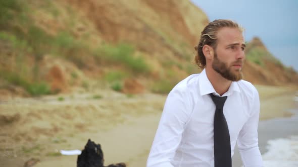 Businesslike Guy in White Shirt and Black Tie Throwing Papers in Air on Sea Cost in Slow Motion