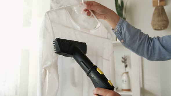 Woman is Steaming Steam Cleaner Shirt in a Room at Home