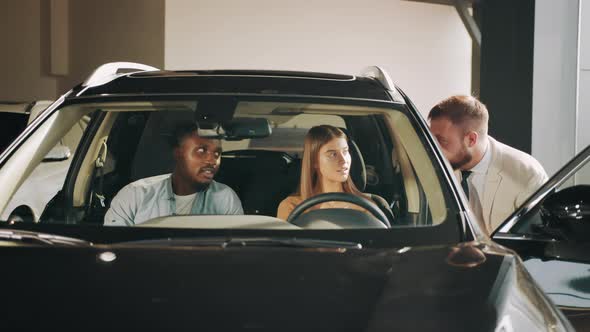 Car Dealer in Formal Outfit Presenting New Model of Luxury Auto to Multicultural