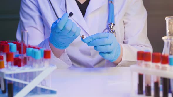 Female Doctor or Nurse Preparing Injection Syringe Filling with Ampoule Liquid in Clinic