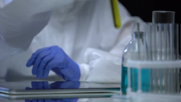 Fuel Lab Assistant Examining Test Tube With Petrol for Sediment, Quality Control