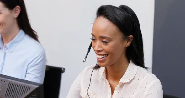 Smiling customer service executives talking on headset at desk 4k