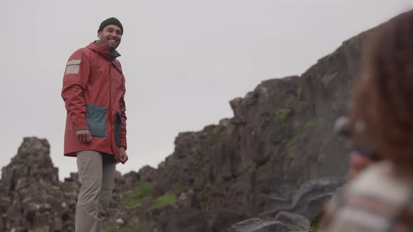 Woman Using Old Camera To Film Man Smiling By Oxararfoss Waterfall